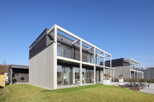 Das Foto zeigt mehrere 2-stöckige Gebäude mit offener Betonpfeilerkonstruktion.