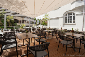 Auf dem Bild ist die Terrasse der Villa sehen, mit Bestuhlung für den Gastronomiebetrieb