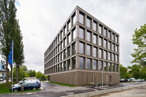 Auf dem Bild sieht man ein zwei Seiten des Bürogebäudes, die Ecke ist im Vordergrund und ragt in den Himmel