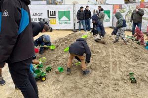 Das Bild zeigt einen Sandspielplatz, auf dem Kinder spielen. Der Sandhaufen wurde beim Brückbaufest für den Spatenstich aufgehäuft und später für Kinder und Familien zum Spielen freigegeben.