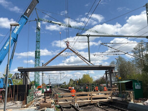 Das Foto zeigt, wie mit einem Schwerlastkran ein 22 Meter langes Brückenteil eingehoben wird.