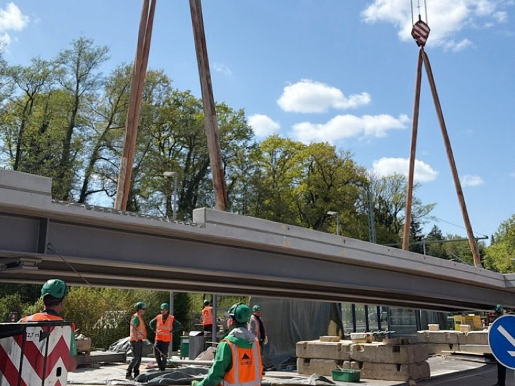 Das Foto zeigt, wie mit einem Schwerlastkran ein 22 Meter langes Br&uuml;ckenteil eingehoben wird.