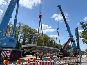 Das Foto zeigt, wie mit einem Schwerlastkran ein 22 Meter langes Brückenteil eingehoben wird.