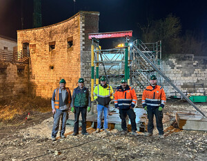 Das Bild zeigt, wie der Schwerlastenkran die Brücke über den Brücken-Widerlager einpasst.