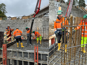 Auf dem Foto sieht man SCHMID Mitarbeiter auf der Baustelle beim Betonieren