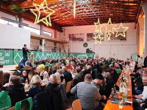 Das Foto zeigt einen Blick über die weihnachtlich geschmückte Zimmereihalle. Der Geschäftsführer Fridolin Schmid hält eine Rede.