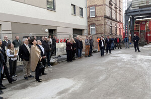 Auf dem Bild sind Menschen zu sehen, die nach oben schauen. Es sind die Gäste des Richtfestes des Bauprojektes Müller im Theaterviertel in Ulm. Unter den Gästen Bauherr Erwin Müller mit Frau.