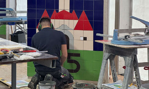 Das Foto zeigt einen Teilnehmer des Wettbewerbes Deutsche Meisterschaft der Bauhandwerke beim Fliesenlegen