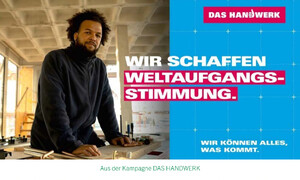 Motiv der Kampagne „DAS HANDWERK“ in einem Rohbau. Eine Person steht an einer Werkbank, daneben ist der Kampagnenslogan „Wir schaffen Weltaufgangsstimmung“ zu sehen. Das Motiv wirbt für die Zukunftsfähigkeit und Bedeutung des Handwerks.