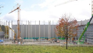 Das Foto zeigt eine Baustelle. Hohe Botonpfeiler ragen in die Luft und es sind Krane sind zu sehen.