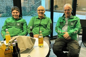 Das Foto zeigt drei Poliere der Firma Matthäus Schmid Bauunternehmen, sitzend im Atrium des SCHMID Verwaltungsgebäudes. Im Vordergrund stehen Getränke. Die Männer hören einen Vortrag der Geschäftsleitung