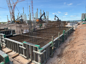 Bewehrte Fundamentkonstruktion auf der Baustelle des neuen Vetter-Produktionsstandorts in Saarlouis. Im Hintergrund sind bereits montierte Betonstützen sowie Krane für die weitere Fertigteilmontage zu sehen.